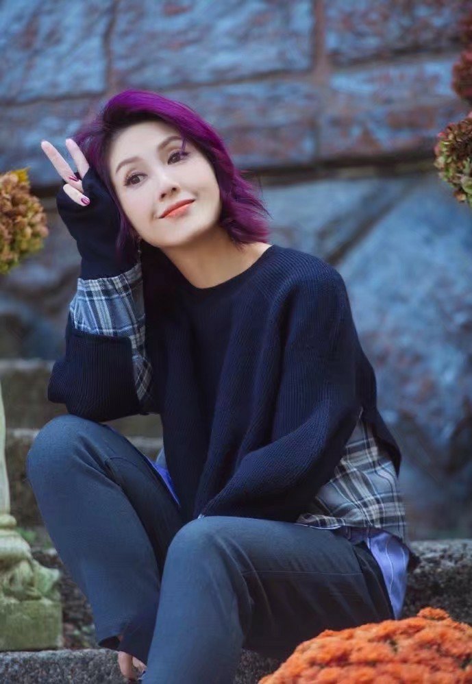 身穿灰色大衣内搭白卫衣,标志性紫发干练潇洒