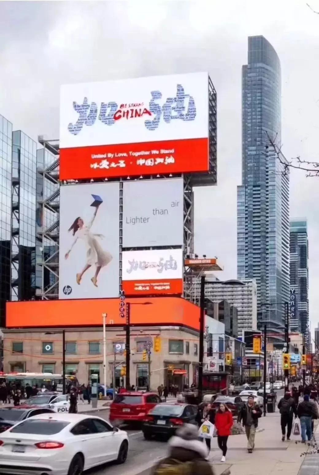 市中心出现的巨幅广告牌也非常暖心:"加油中国!以爱之名!我们挺你!