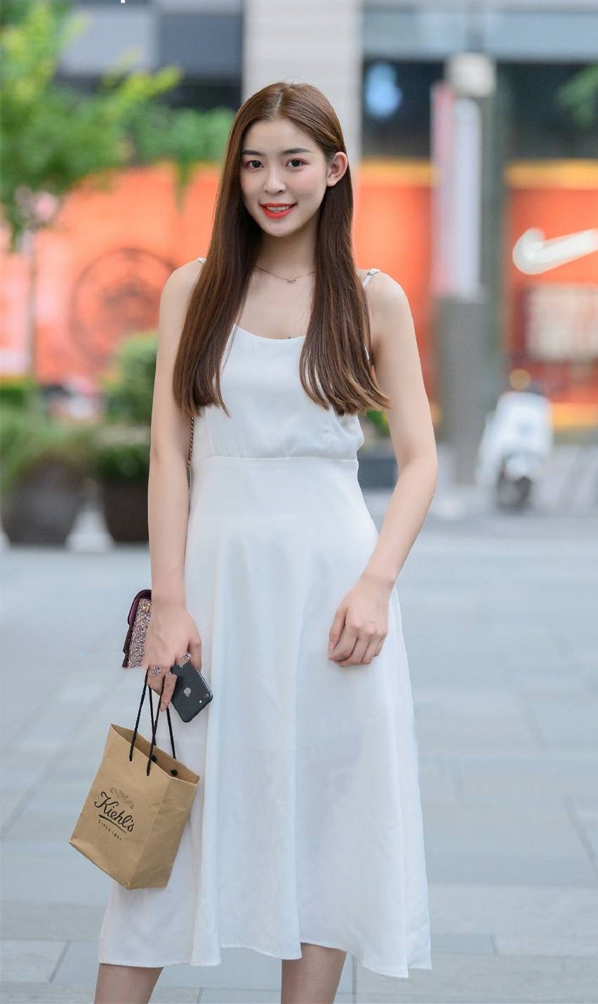 纯白色的吊带裙,凸显了窈窕的身姿,展现了纯美的淑女气质