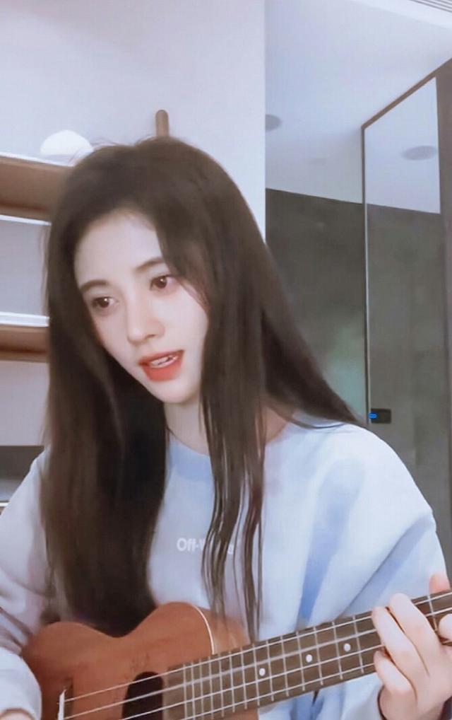 鞠婧祎清纯可人,身穿浅蓝色卫衣怀抱尤克里里,尽显优雅身姿