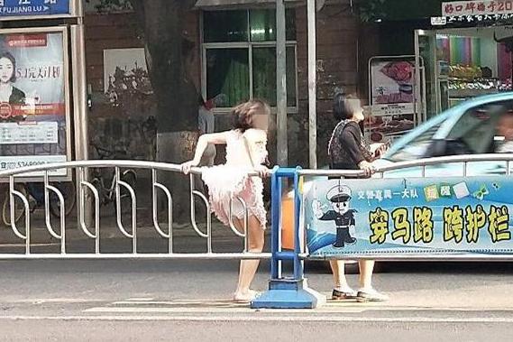 夏天穿裙子最好不要翻越护栏因为很容易走光