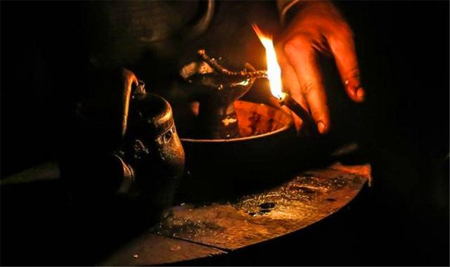 用一个小水罐,萨波日尼科夫把亚麻籽油倒入一盏灯(一个中世纪小夜灯)