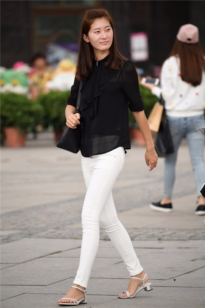 路人街拍,穿着黑衫白裤的凉鞋美女,微笑中透露着自信