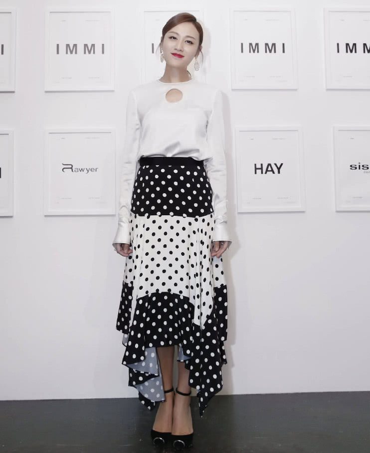 叶一茜身穿白色上衣,搭配黑白色波点半身裙,配上一双纯黑高跟鞋,妆容