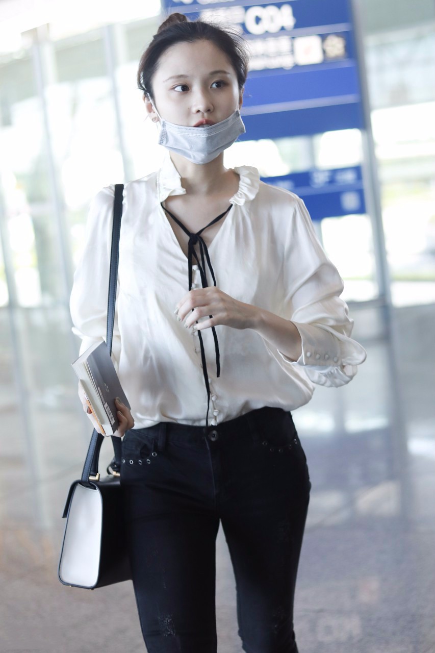 张慧雯穿白色衬衣搭配黑色裤子现身机场皮肤白皙,扎丸子头好可爱
