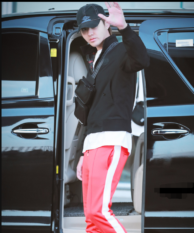 吴亦凡身穿黑色卫衣搭配红色运动裤现身机场面带微笑心情很好