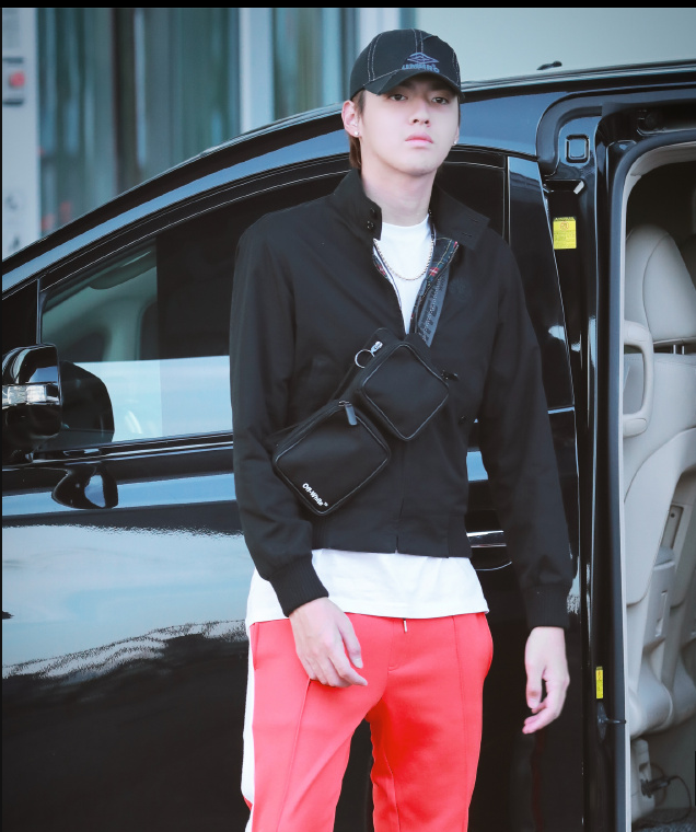 吴亦凡身穿黑色卫衣搭配红色运动裤现身机场面带微笑心情很好