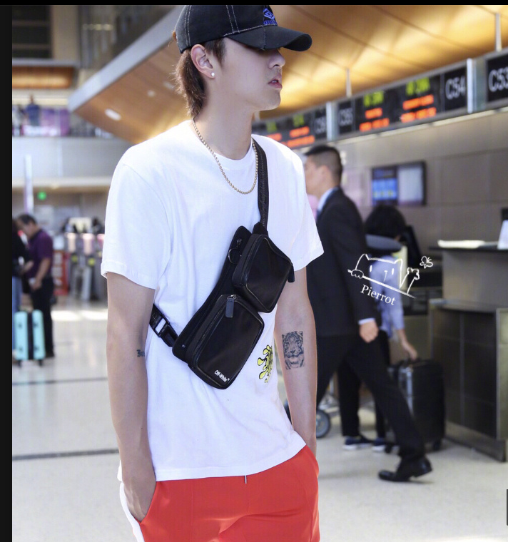 吴亦凡身穿黑色卫衣搭配红色运动裤现身机场面带微笑心情很好