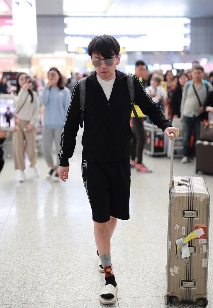 雷佳音最新机场照, 拖鞋配袜子表情迷茫, 身后妹子掩面而笑!