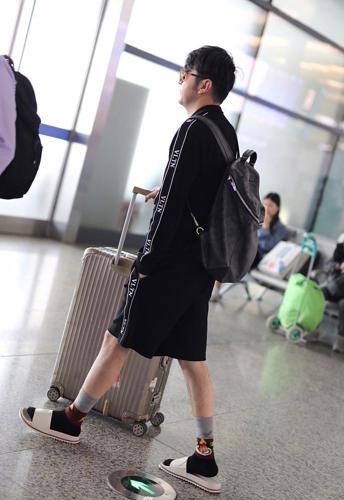 雷佳音最新机场照, 拖鞋配袜子表情迷茫, 身后妹子掩面而笑!