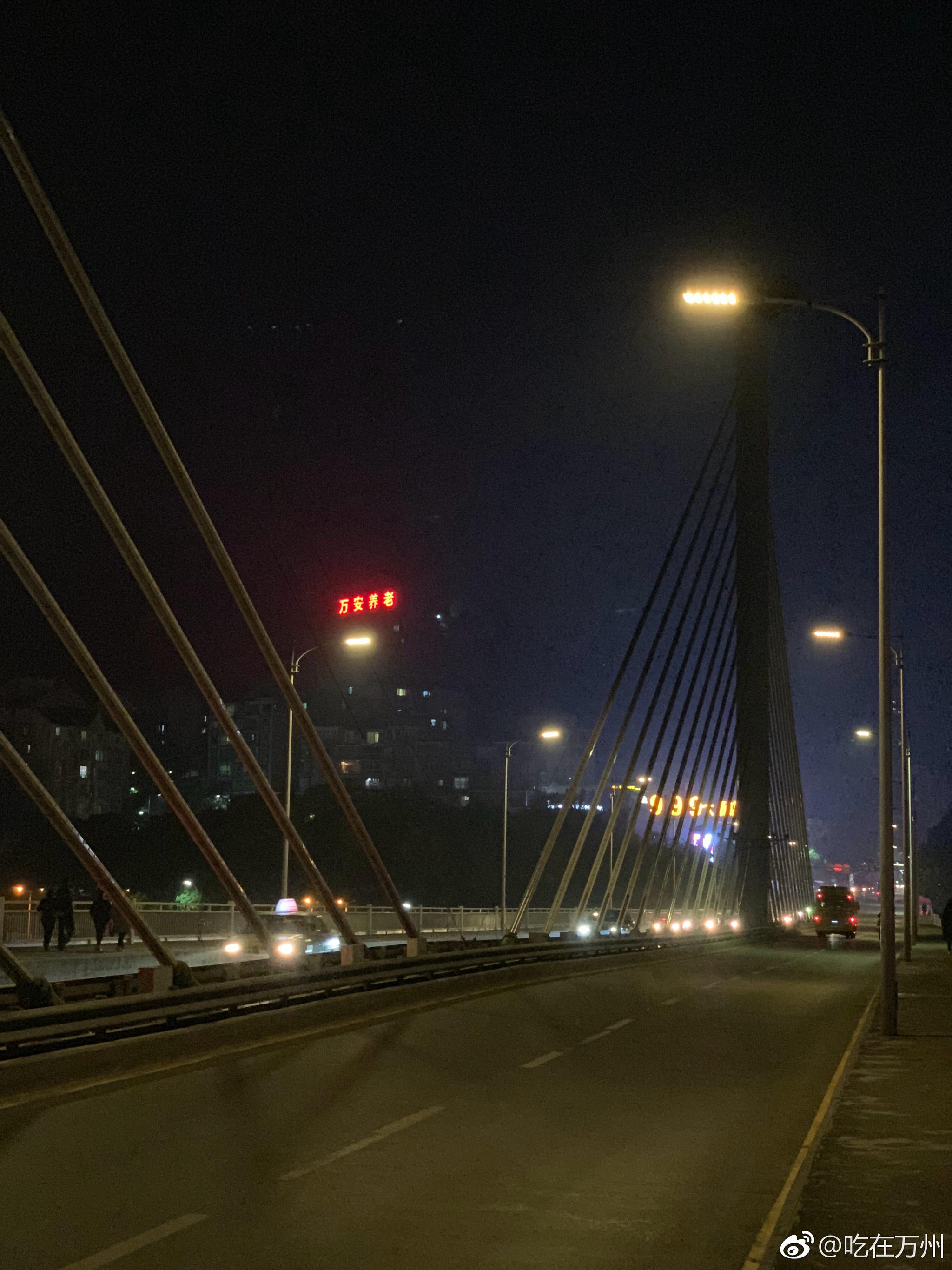 行走在夜色的万安大桥上看着桥以北以南的万州夜晚