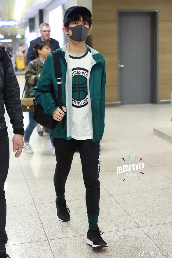 他头戴黑色棒球帽,戴着黑色口罩遮面,身穿绿色外套搭配黑色紧身裤