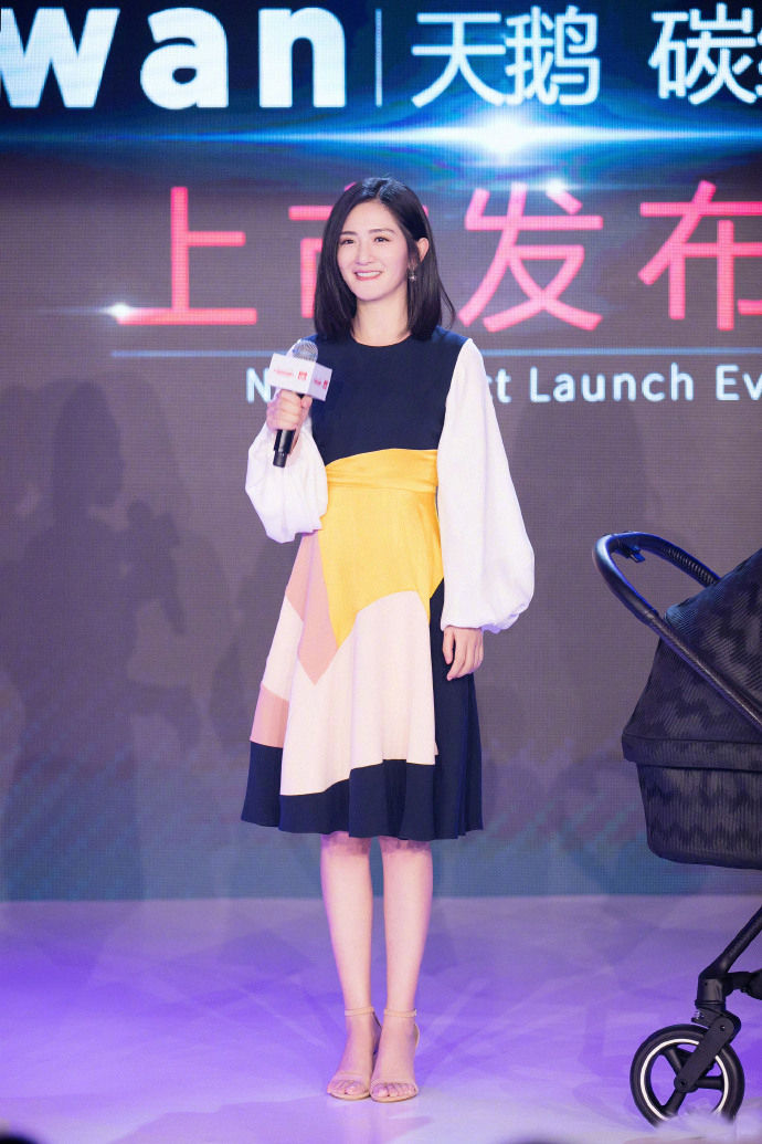 在好孩子的发布会上,谢娜长发披肩,身穿黑白黄拼接连身裙,秀出美腿