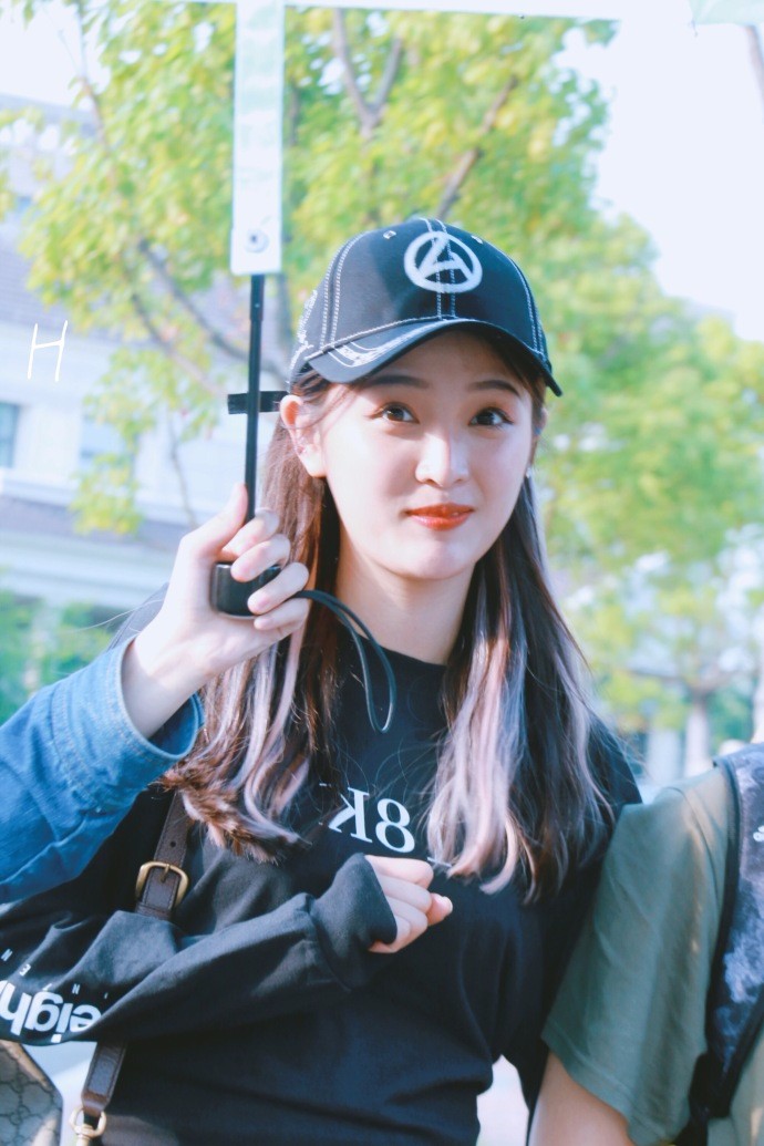 吴宣仪戴棒球帽穿黑色卫衣搭配黑色运动裤现身,肤白貌美笑容甜美