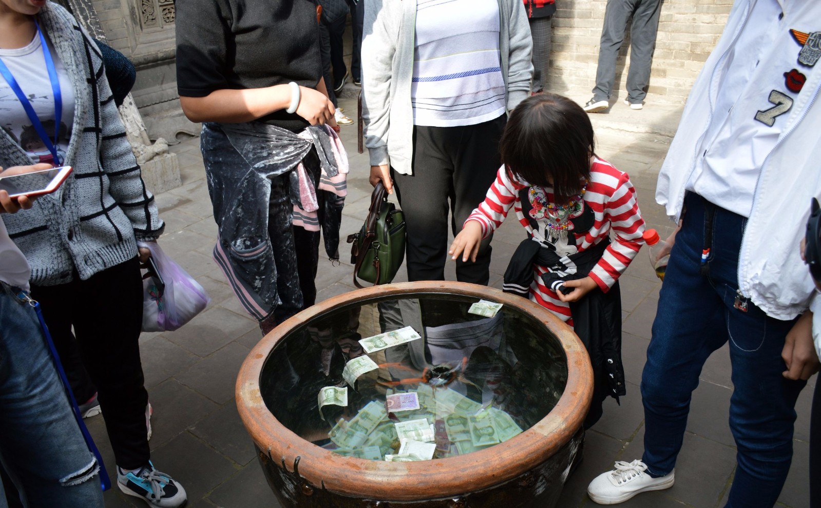 景区鱼缸被游客当成许愿池疯狂投币砸懵金鱼