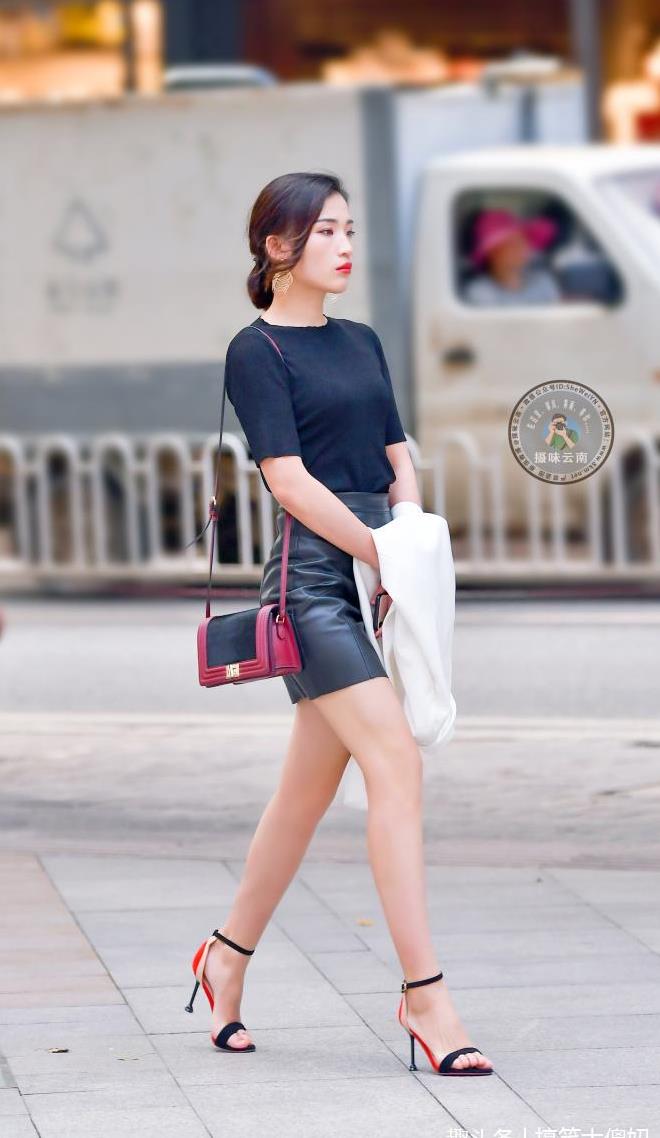 路人街拍:小姐姐身穿黑色皮裙,脚踩一字高跟鞋,走路时姿态婀娜