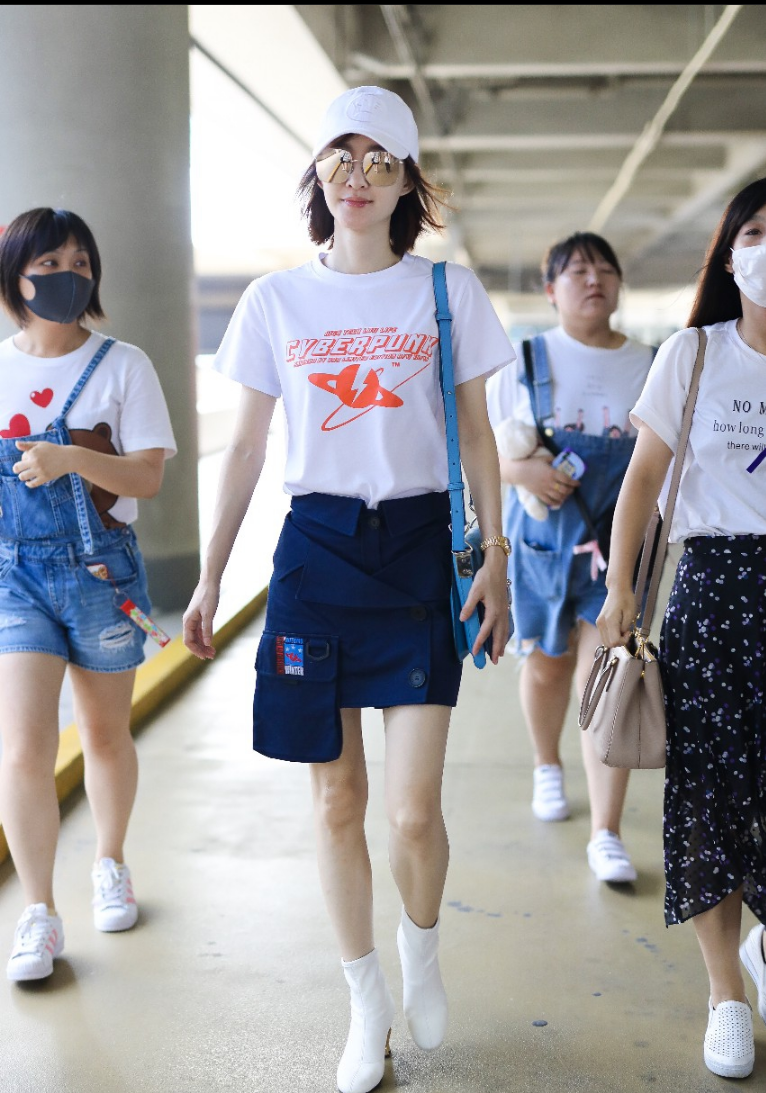 33岁的王丽坤身着白色t恤搭配深蓝色短裙现身机场依然少女范十足