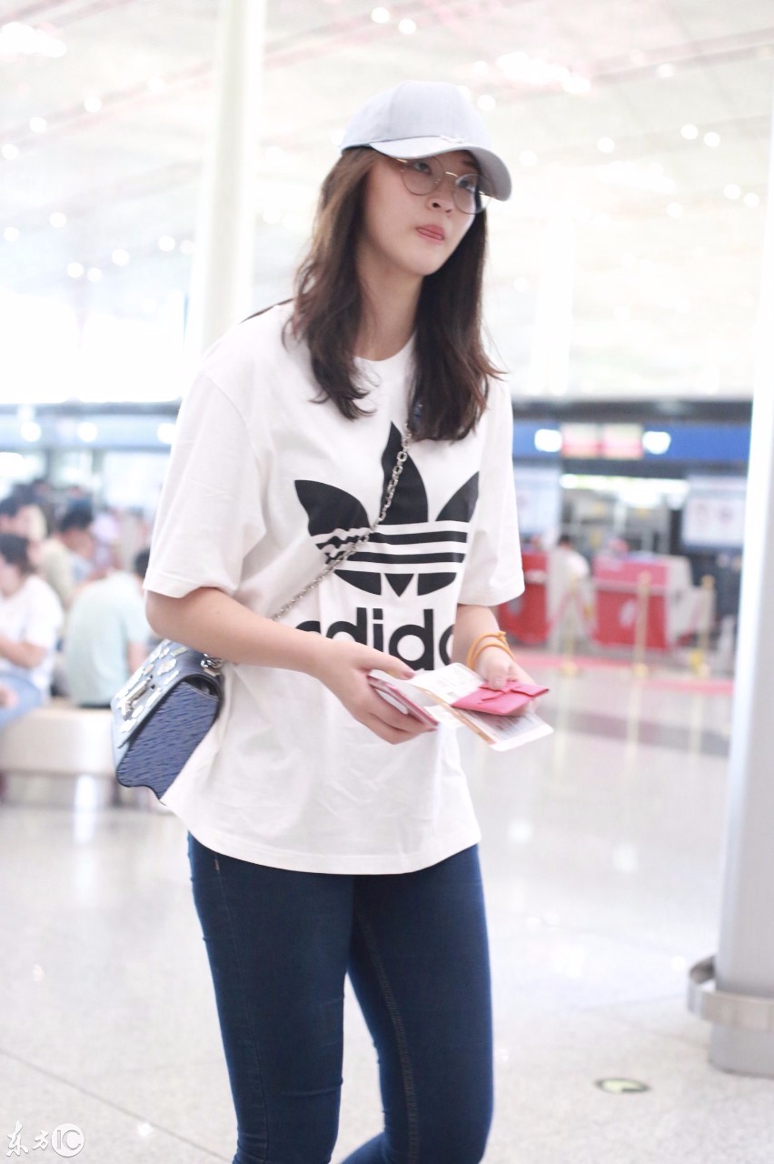 惠若琪穿白色t恤搭配深蓝色牛仔裤现身机场皮肤白皙面带微笑