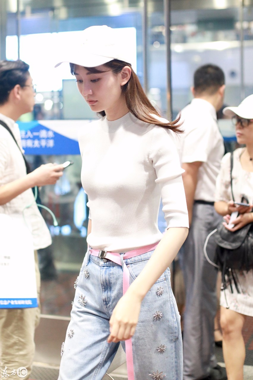 乔欣戴棒球帽穿白紧身衣搭配牛仔裤现身机场,皮肤白皙大秀好身材
