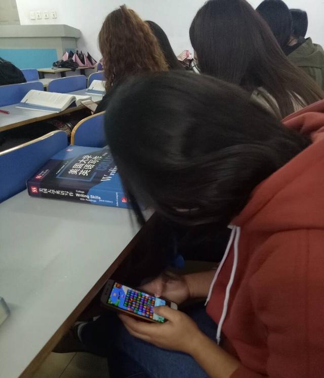 大学生上课前两排空位没人坐, 后排坐满人, 上课低头玩手机