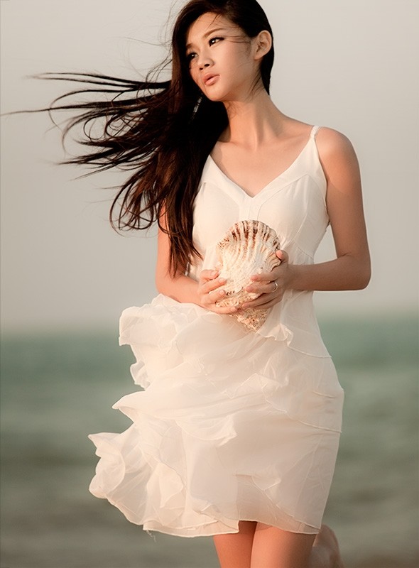 海景边黄昏下的一个长发飘逸女子