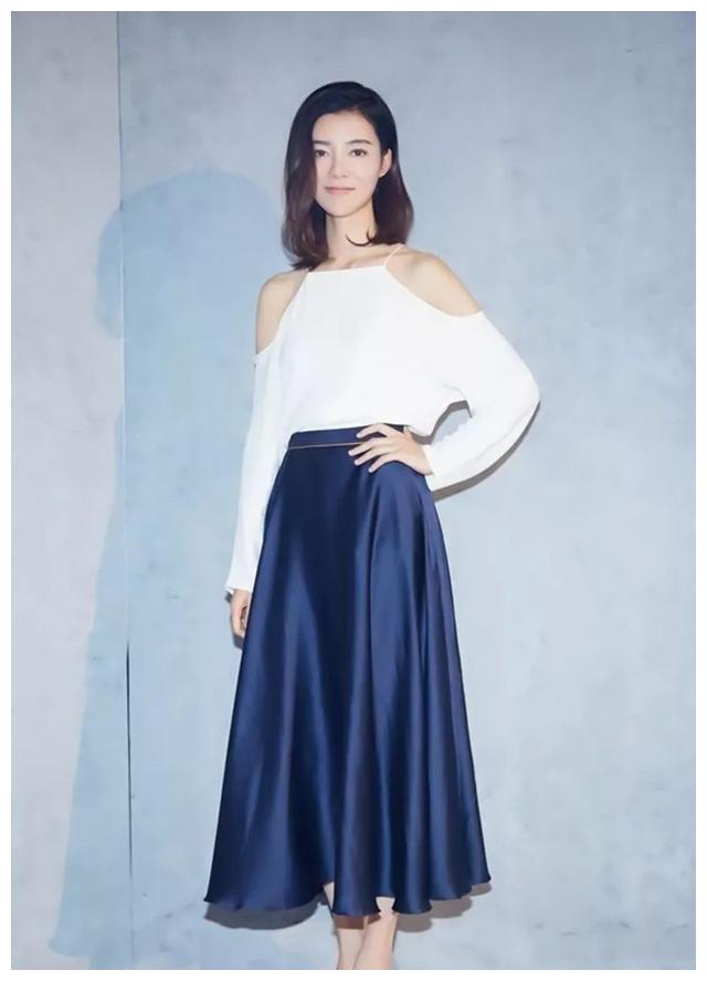 高端洋气的白色上衣,搭配一条蓝色百褶裙,淑女气质,格外迷人,同时露出