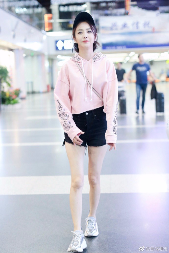 佟丽娅穿粉色卫衣搭配黑色牛仔短裤现身机场,肤白貌美笑容甜美!