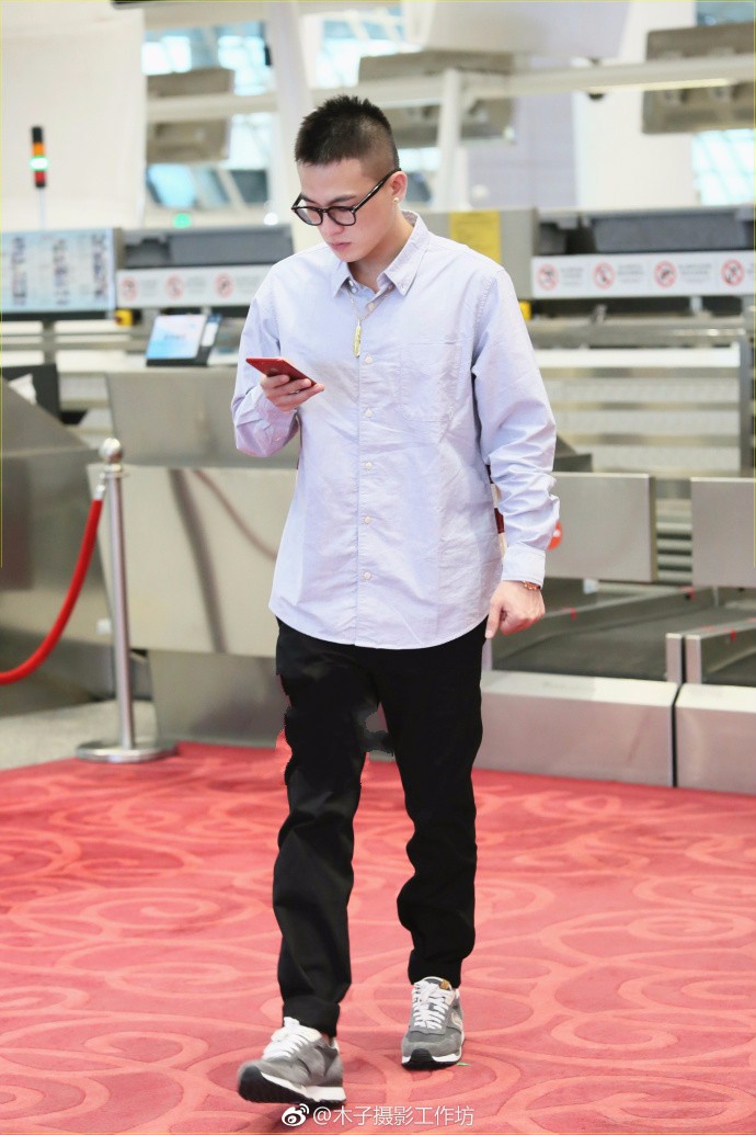 欧豪戴眼镜穿衬衣搭配休闲裤现身机场帅气十足,玩手机变身低头族