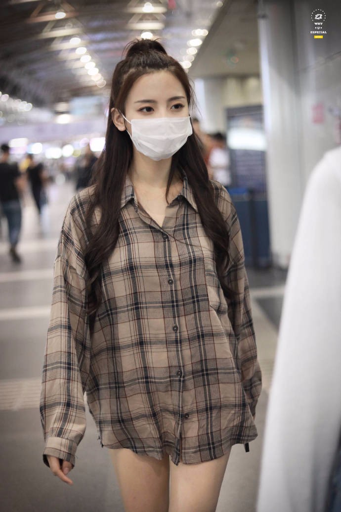 杨超越扎马尾辫戴白口罩穿格子衬衫现身机场,仗着腿长玩下衣消失