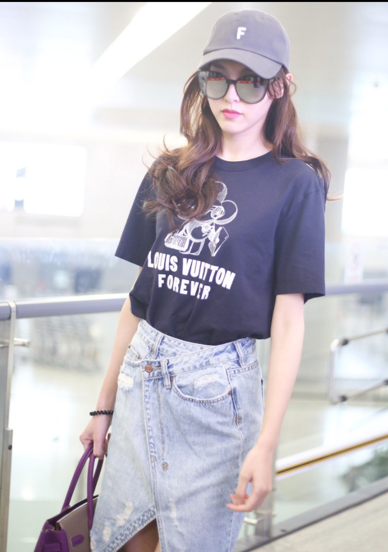 唐嫣穿不规则牛仔裙现身机场笑容甜蜜笔直的筷腿实力抢镜