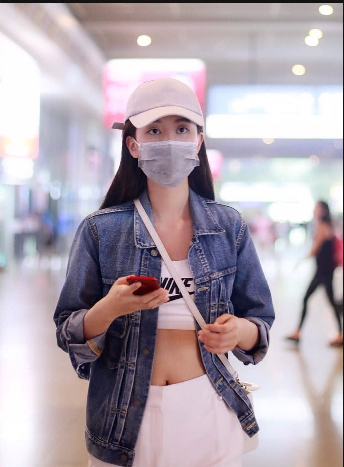 蒋欣身穿牛仔外套内搭白色运动内衣现身机场露肚脐秀性感小蛮腰
