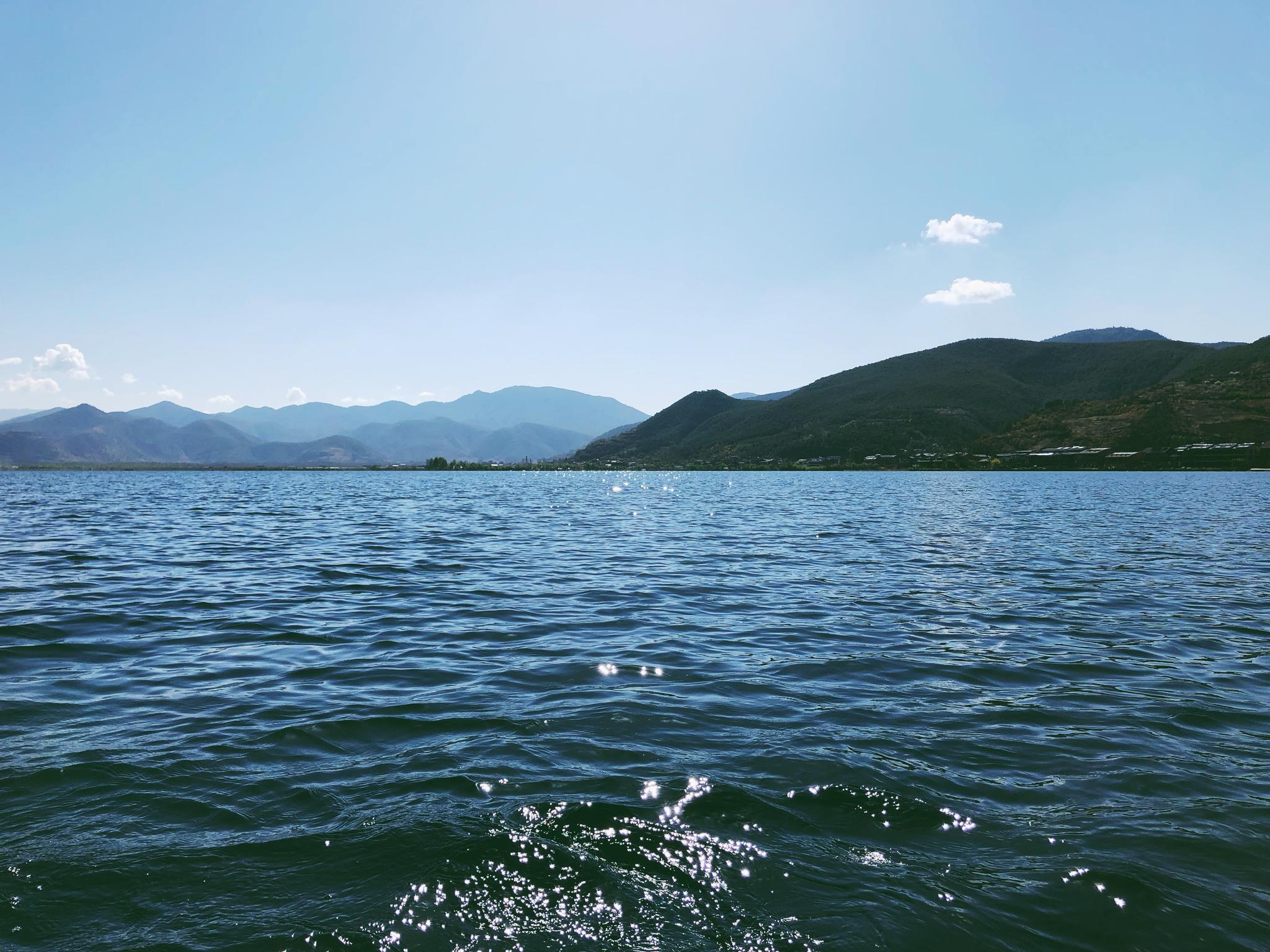 划船在泸沽湖湖面上,看着湛蓝的湖水