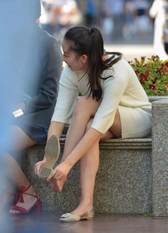 街拍在街边低头穿鞋的大姐这身搭配长得很丽人