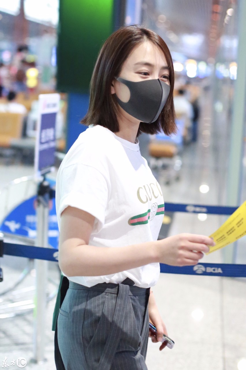 马苏戴口罩穿白色t恤搭配灰色西裤现身机场,心情十分不错.