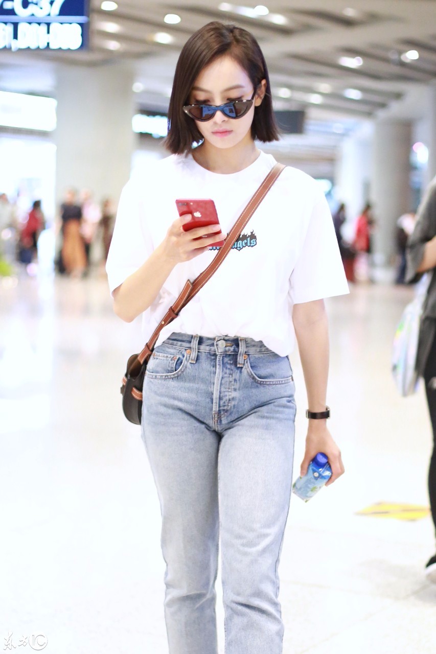 宋茜戴墨镜穿白色t恤搭配蓝色牛仔裤现身机场走路时低头玩手机