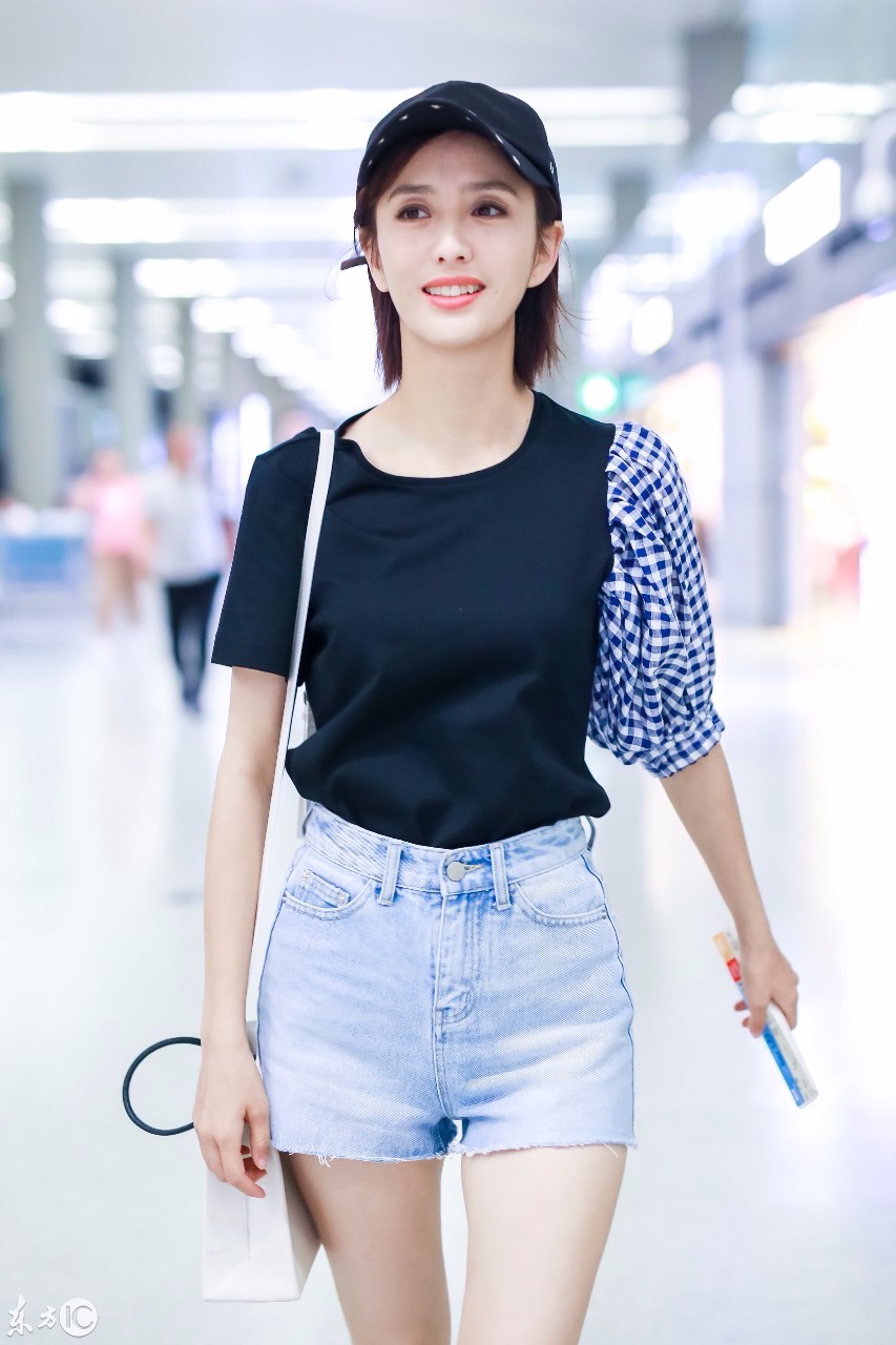 佟丽娅戴棒球帽穿黑t搭配牛仔短裤现身机场,笑容甜美大秀美腿!
