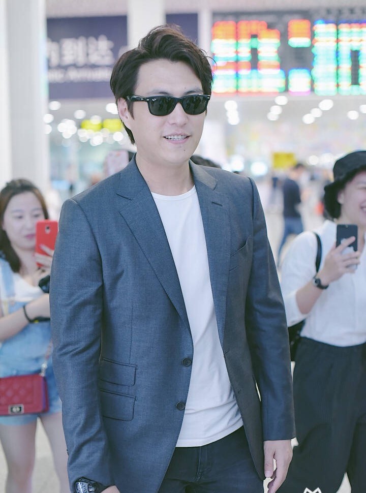 靳东穿着灰色西装戴着墨镜现身机场 帅气有型笑容面面心情大好