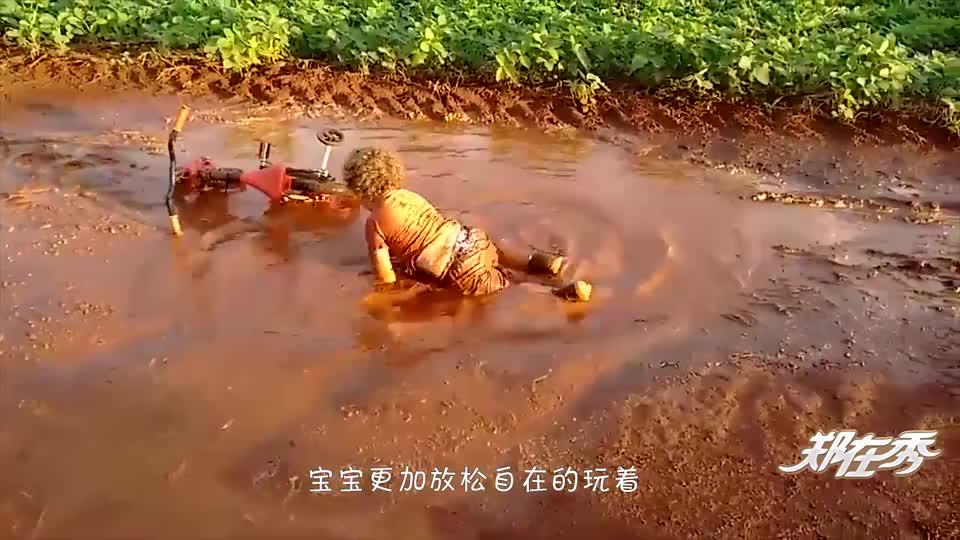 熊孩子在水坑里各种打滚,都变成泥人了,亲爸就在旁边边看边拍!