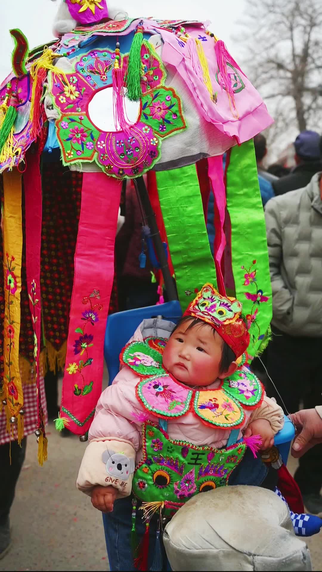 1岁社火娃娃头戴虎帽人群中谁也不怵颇有大将风度