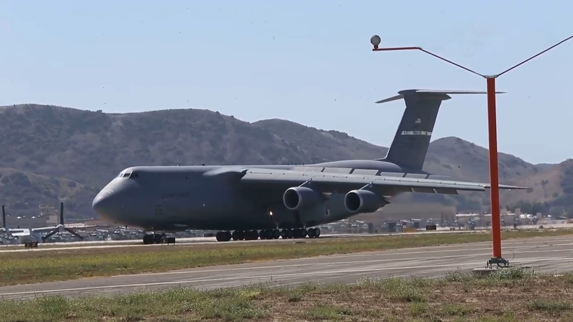 美军一架c-5运输机,在一处军事基地降落,地上停着各种直升机!