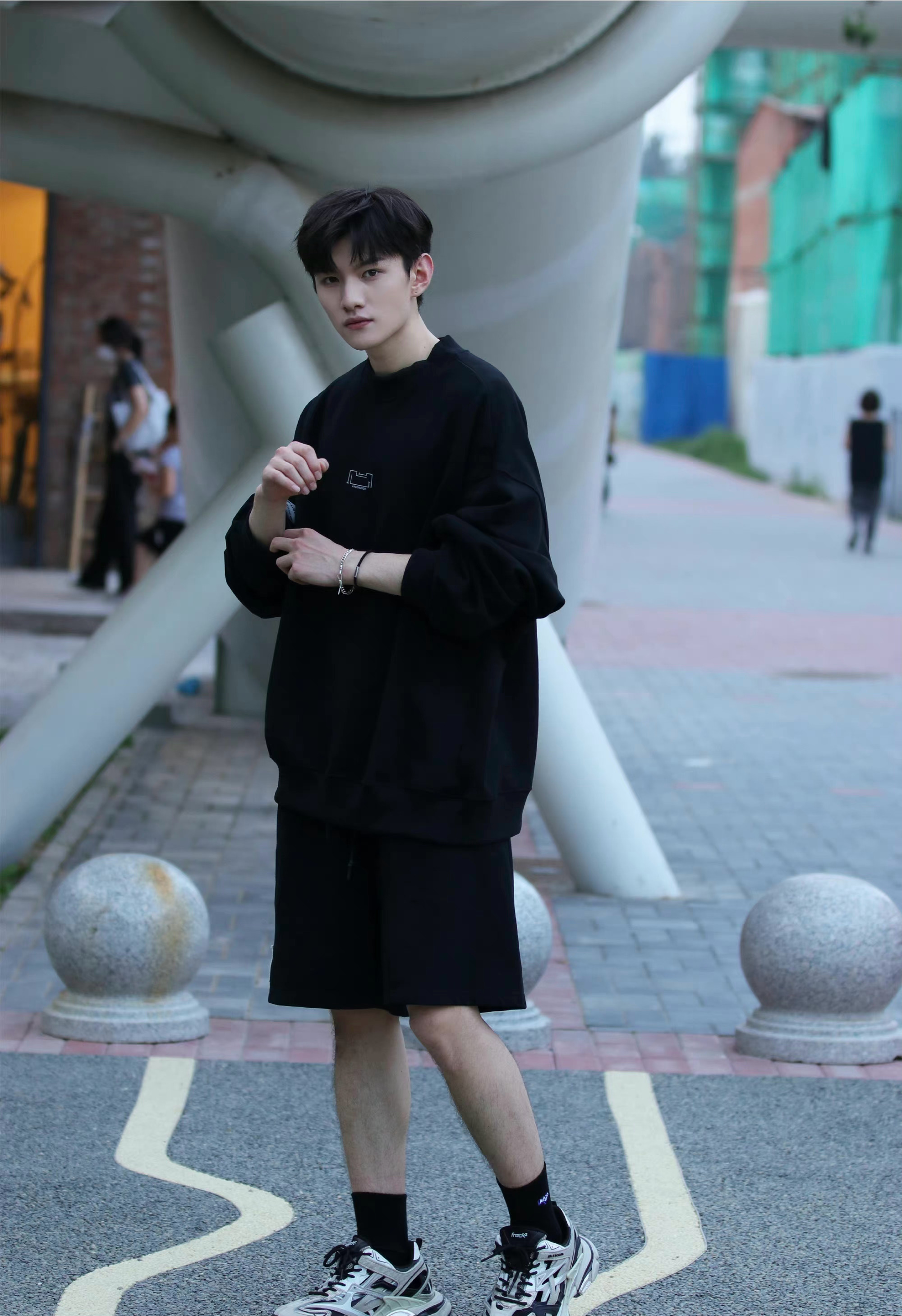 王佳玉身穿黑色运动服,时尚又有型,元气男孩展露笑颜