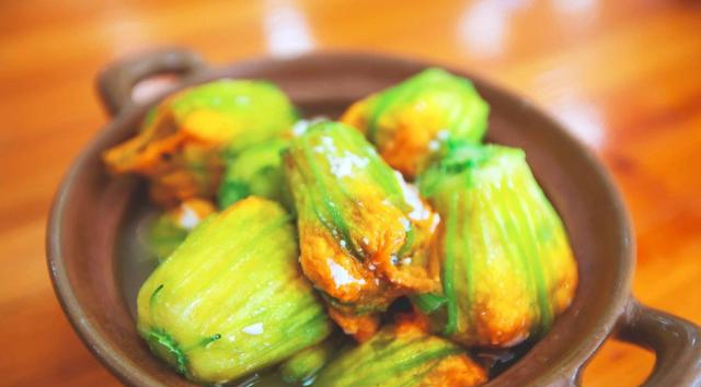 5,然后我们取一朵沥干水分的南瓜花,用勺子舀入调好