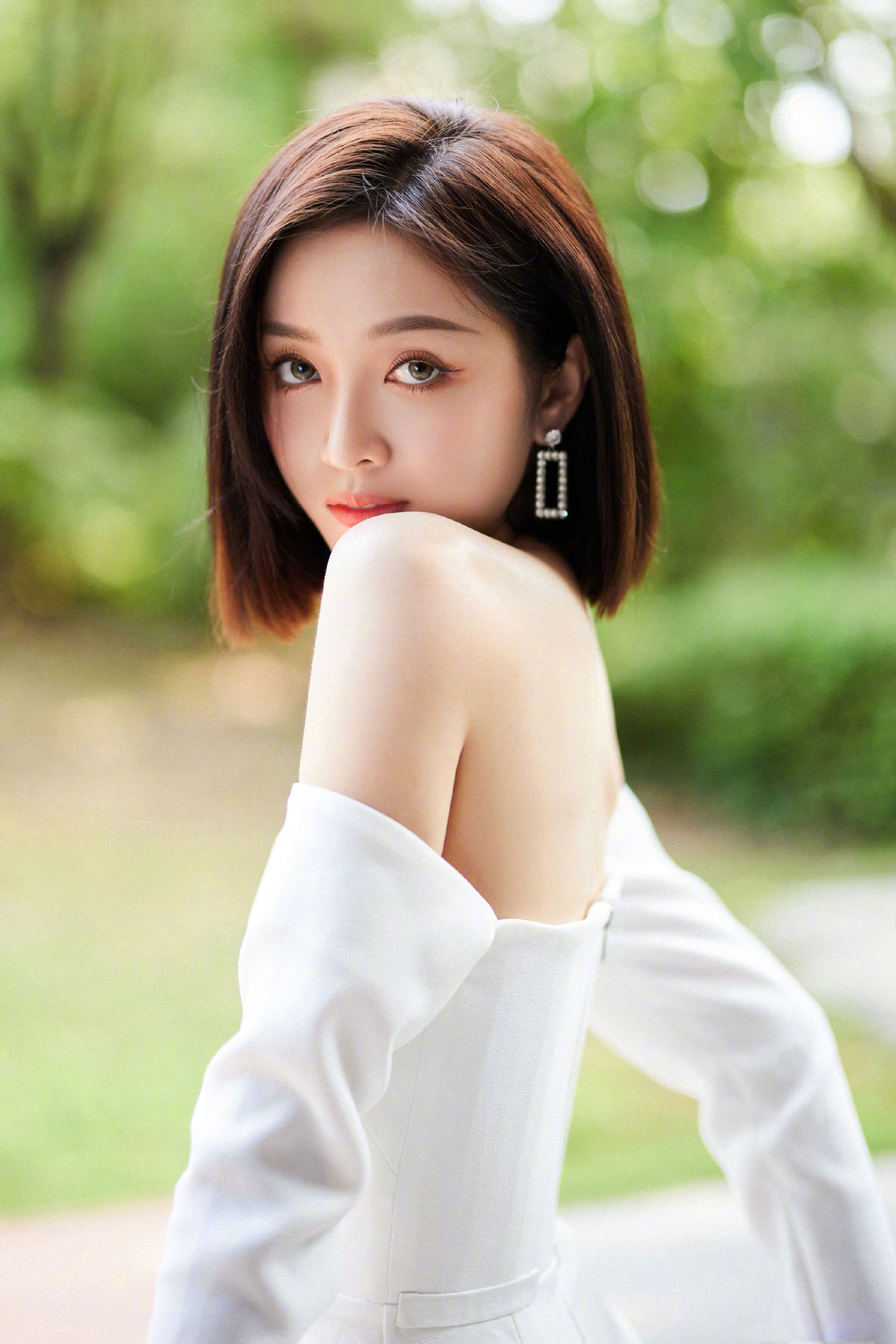 吴宣仪身穿一袭抹胸漏肩白色短裙,短发干净利落,尽显妩媚风情