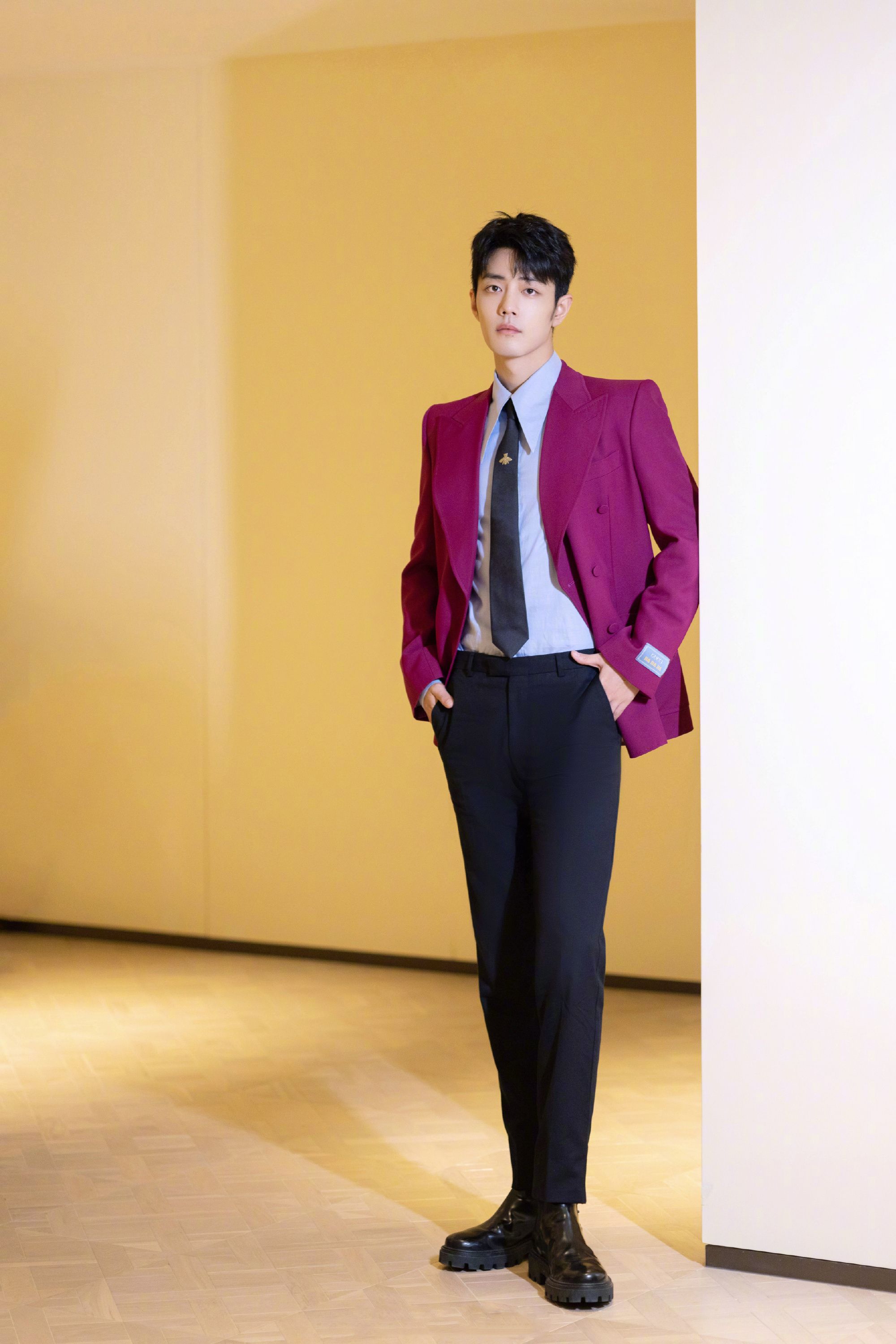 在红毯上的肖战一身红色西装黑色领带上的小蜜蜂点睛