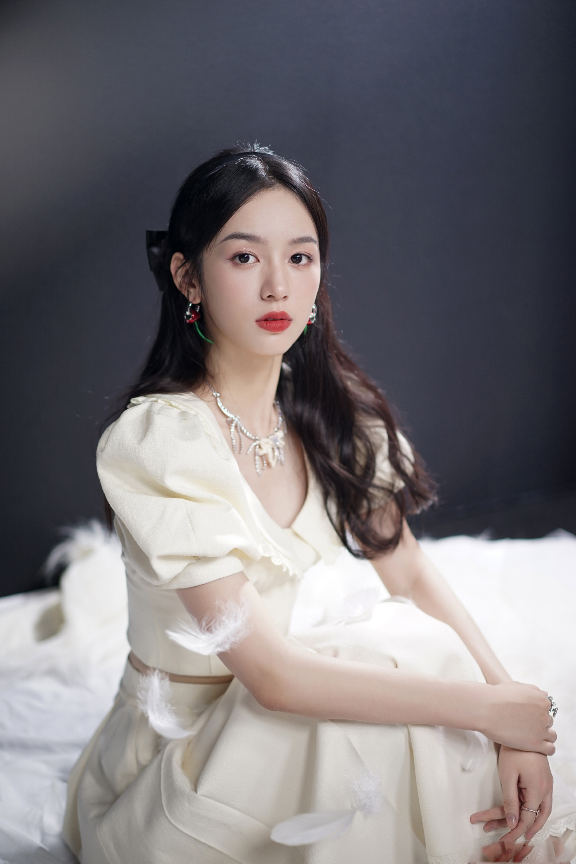 周也最新活动造型身穿奶白色长裙搭配浪漫卷发佩戴樱桃耳环