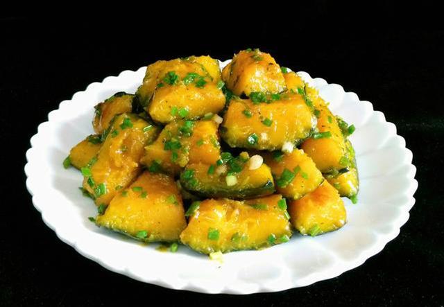 适量的油烧热放入一半的葱倒入南瓜煸炒加入蚝油加入适量的水盖上锅盖