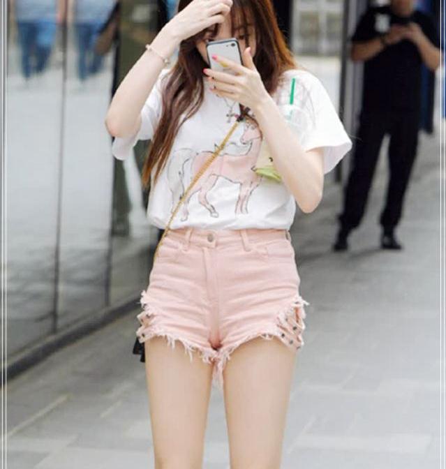 街拍:爱美的小姐姐在路边拍照,衬衫短裤的搭配清新十足