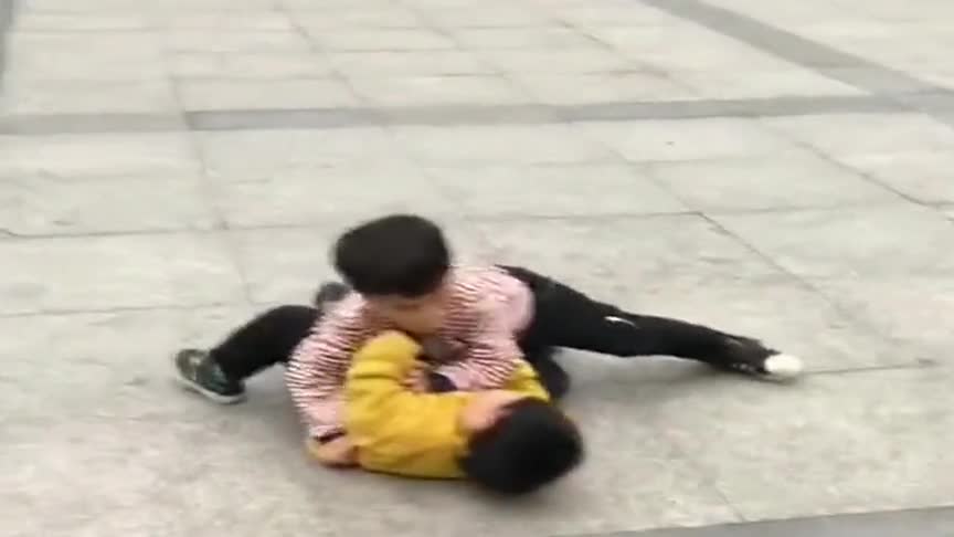 两个小孩打架,黄衣小朋友上来就一记扫堂腿,结果却把自己撂倒了
