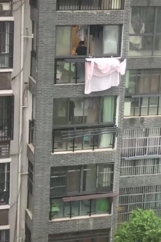 下雨天,无意间拍到对面楼上这一幕,两口子都是人才啊!
