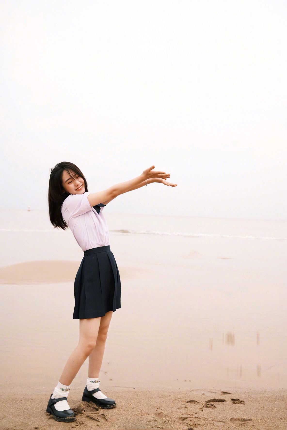 邢菲这组海边照片青春感十足.蓝天白云下的沙滩上,风吹过长发